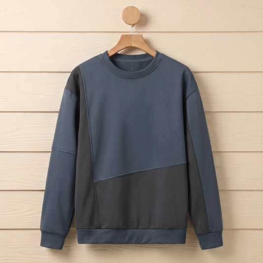 Slate blue and charcoal grey colour block crew neck sweater hanging on a wooden hanger