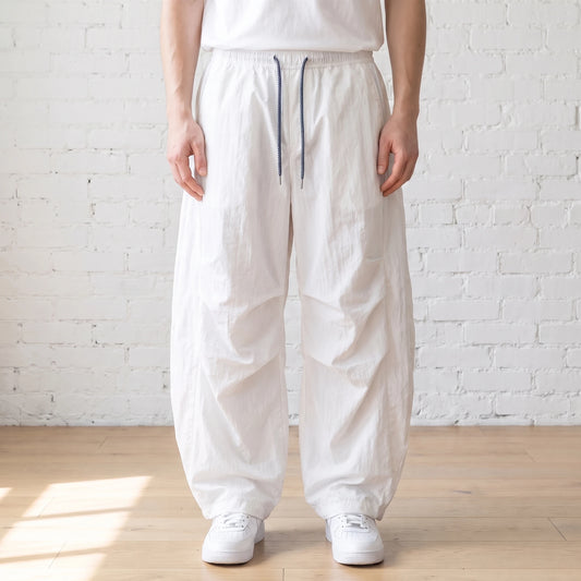 white crinkle wide leg pants worn with a white tee and trainers