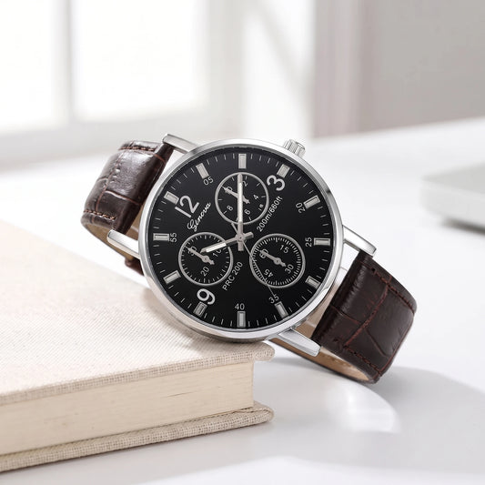 Black dial quartz watch with a brown croc-grain strap resting on a cream book