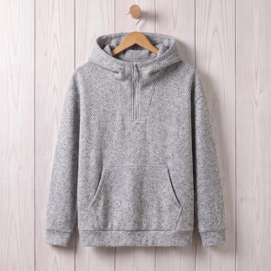Light grey loose hooded sweater with a short zip and kangaroo pocket hanging on a wooden hanger