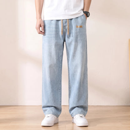 Light blue baggy drawstring jeans with a wide straight leg worn with white sneakers