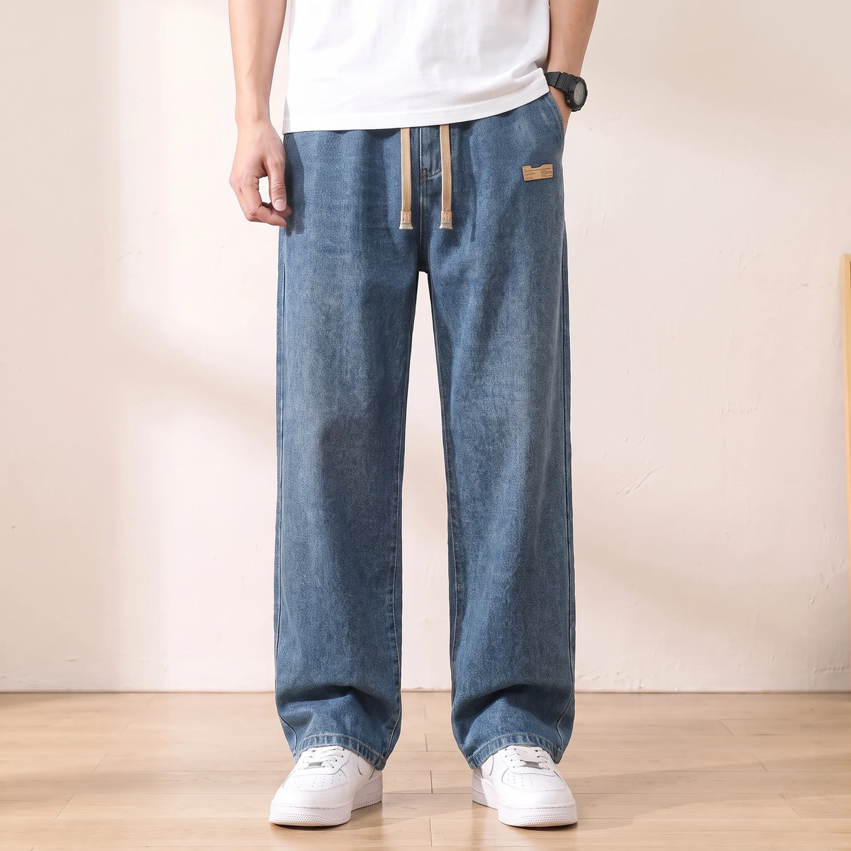 Deep blue baggy drawstring jeans with a wide straight leg worn with white sneakers