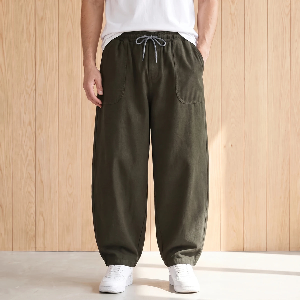 Army green barrel leg trousers with a drawstring waist and large hip pockets worn with a white tee and sneakers