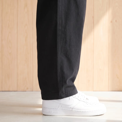 Close-up of the wide lower leg and ankle opening of the black barrel leg trousers