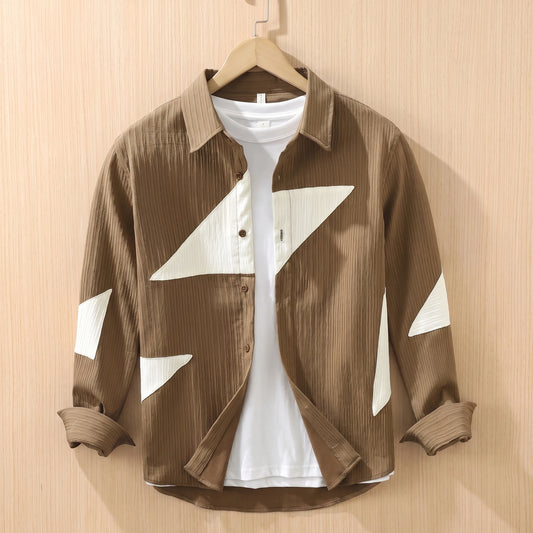 Brown textured shirt with large cream contrast panels hanging on a wooden hanger