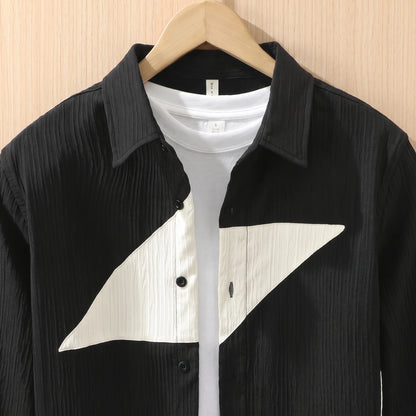 Close-up of the collar, buttons and cream chest panel on a black textured shirt