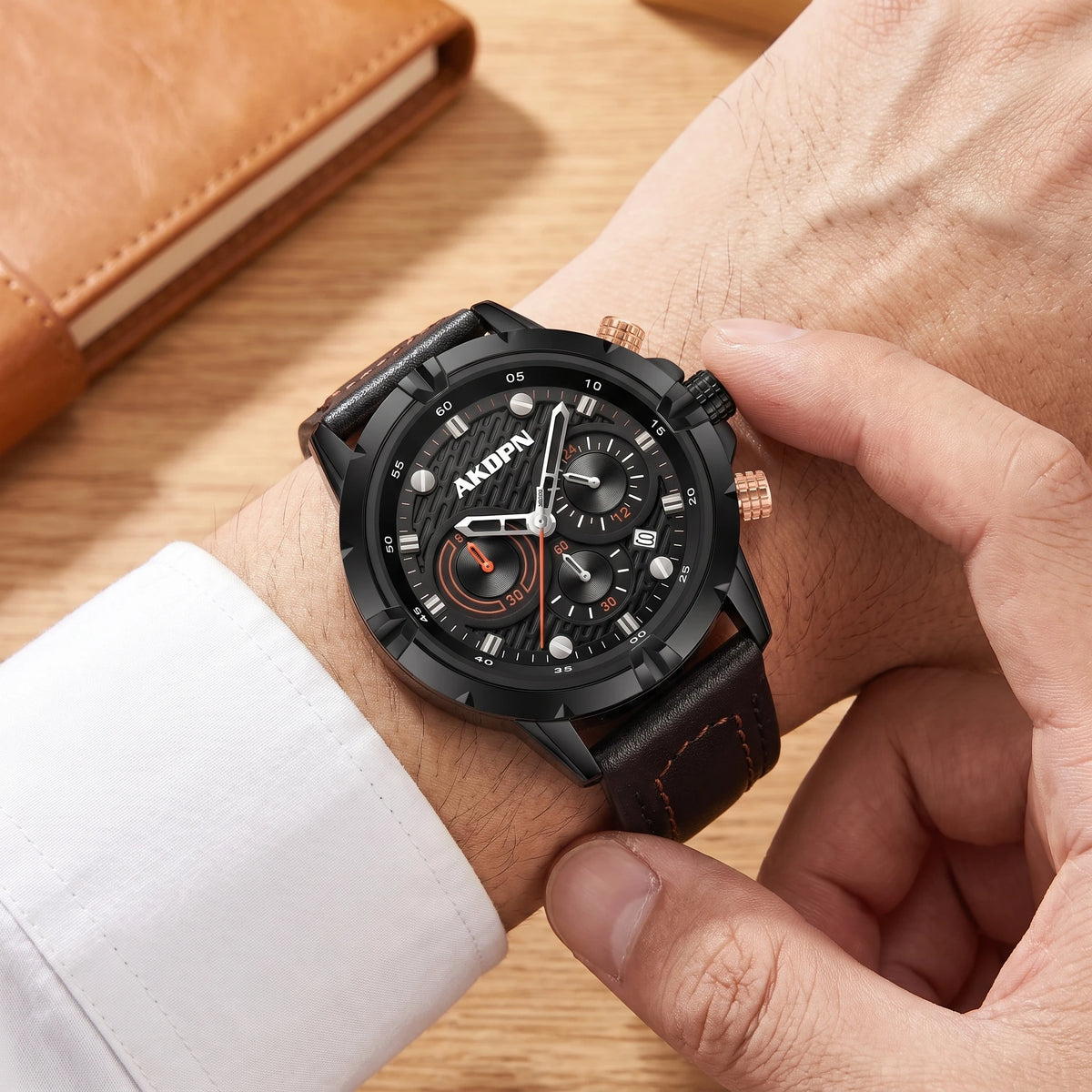 Man wearing a black sports watch with a leather strap and a white shirt cuff