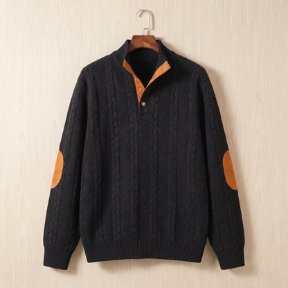 Black cable knit sweater with a stand collar, button neck and tan elbow patches hanging on a wooden hanger