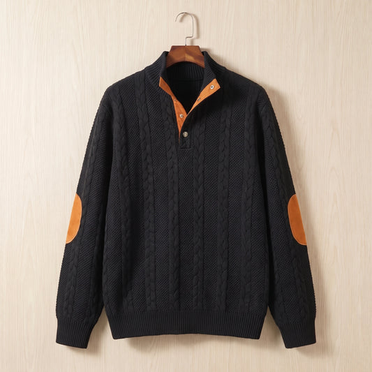 Black cable knit sweater with a stand collar, button neck and tan elbow patches hanging on a wooden hanger