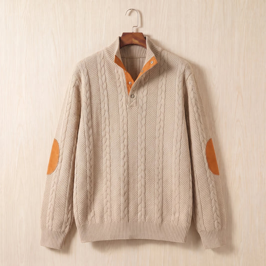 Khaki cable knit sweater with a stand collar, button neck and tan elbow patches hanging on a wooden hanger