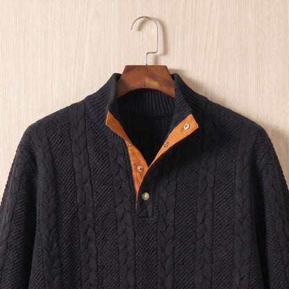 Close-up of the stand collar, two-button placket with tan facing and cable knit on the black sweater