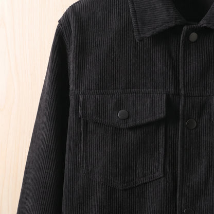 Close-up of the chest flap pocket and snap on the black corduroy jacket