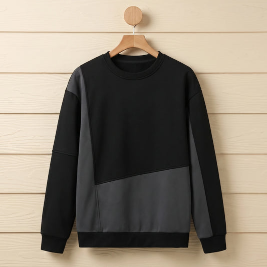 Black and charcoal grey colour block crew neck sweater hanging on a wooden hanger