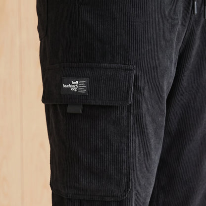 Close-up of the large side cargo pocket and label on black corduroy joggers