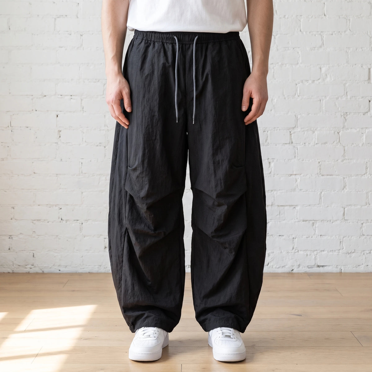 black crinkle wide leg pants worn with a white tee and trainers
