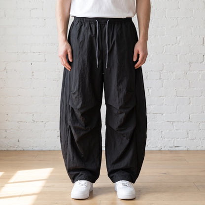 black crinkle wide leg pants worn with a white tee and trainers