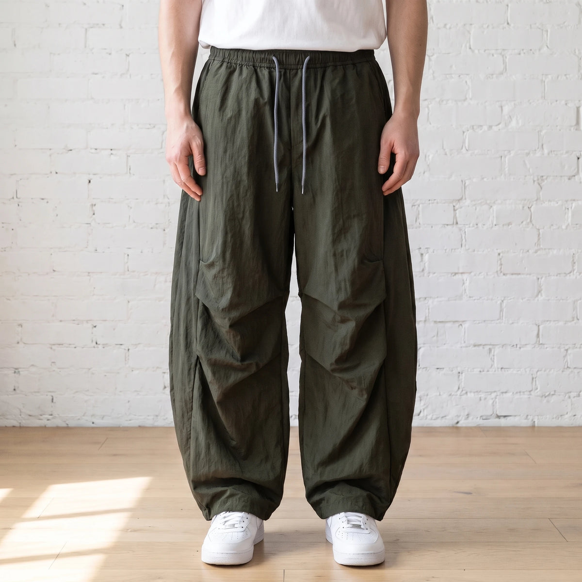 green crinkle wide leg pants worn with a white tee and trainers