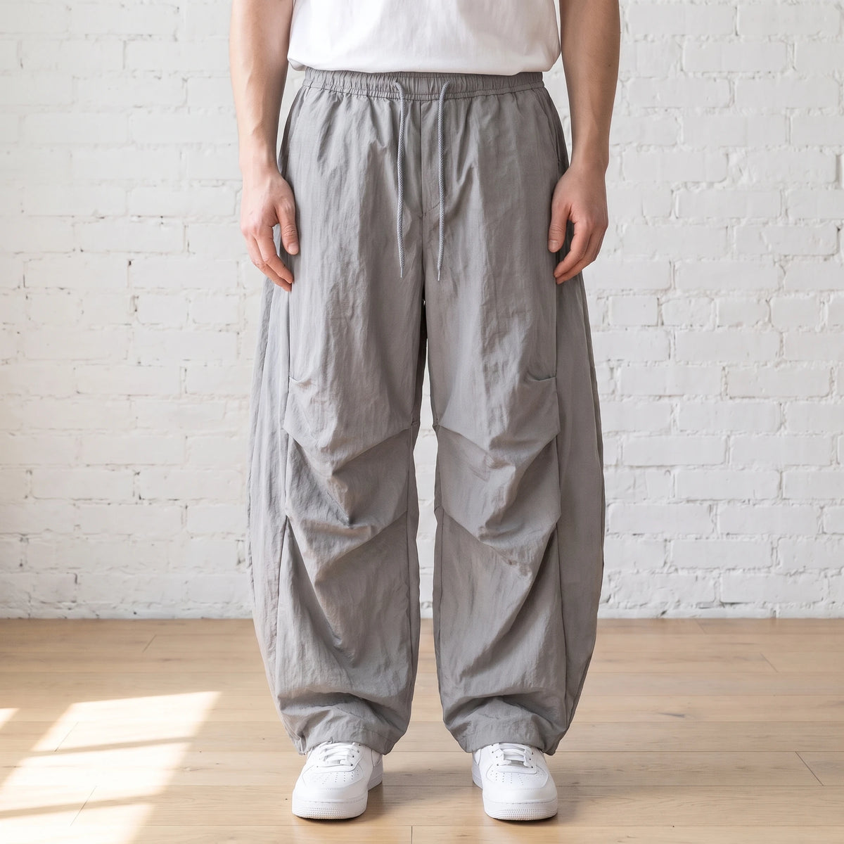 grey crinkle wide leg pants worn with a white tee and trainers