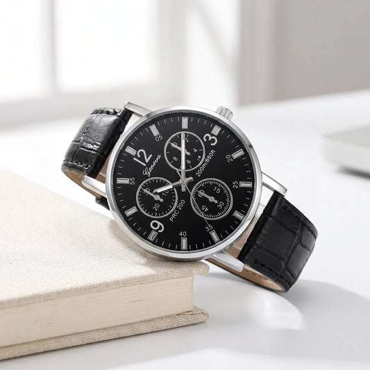 Black dial quartz watch with a black croc-grain strap resting on a cream book