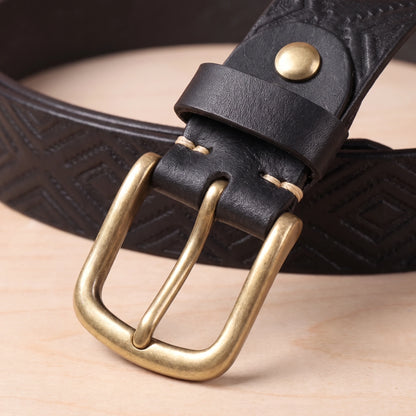 Close-up of the brass pin buckle and riveted keeper on the black embossed leather belt
