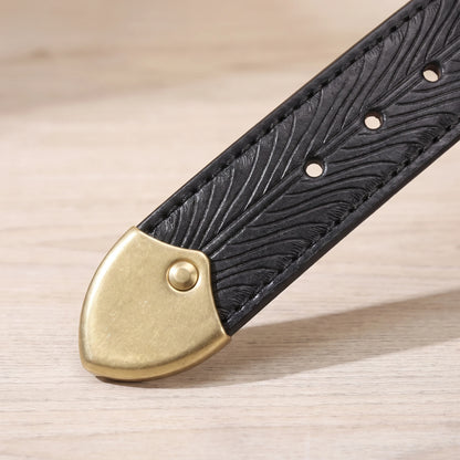 Close-up of the brass shield tip and feather pattern on the black leather belt strap