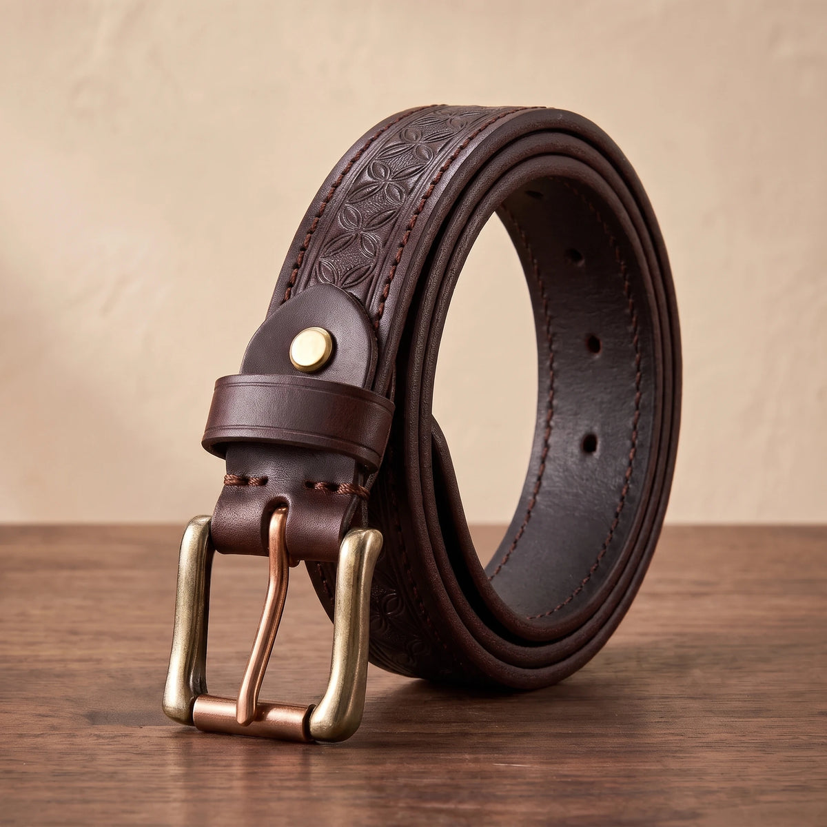 Brown floral embossed leather belt with a brass buckle and copper roller bar