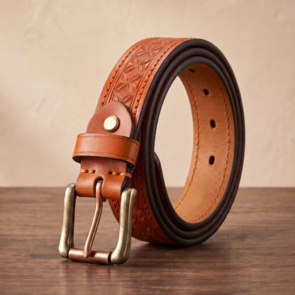 Tan floral embossed leather belt with a brass buckle and copper roller bar