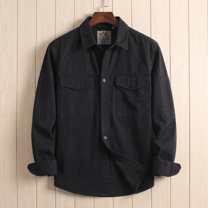 Black heavy cotton overshirt with two flap chest pockets hanging on a wooden hanger