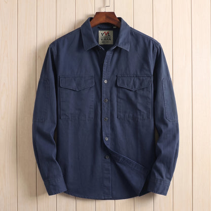 Navy blue heavy cotton overshirt with two flap chest pockets hanging on a wooden hanger