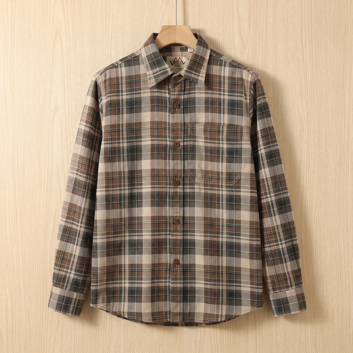 Khaki brown heavy cotton plaid shirt with a chest pocket hanging on a wooden hanger