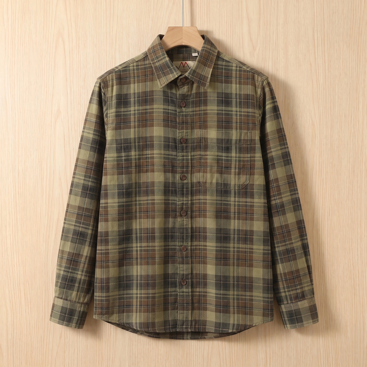 Green heavy cotton plaid shirt with a chest pocket hanging on a wooden hanger