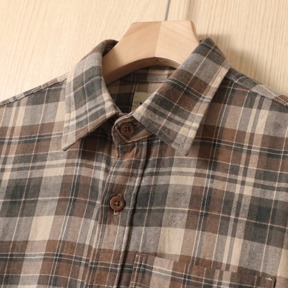 Close-up of the collar and buttons on a khaki brown plaid cotton shirt