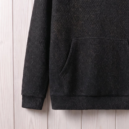 Close-up of the kangaroo pocket, ribbed cuff and hem on the black hooded sweater
