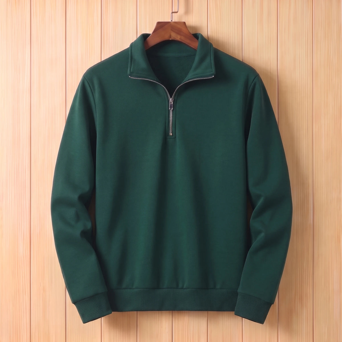 Dark green half zip sweater with a folded collar and ribbed cuffs hanging on a wooden hanger