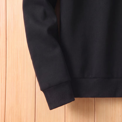 Close-up of the ribbed cuff and hem on the black sweater sleeve