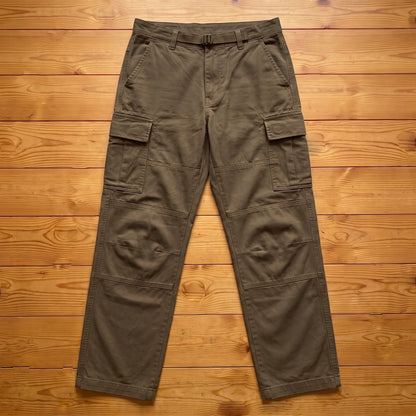 Brown relaxed cargo trousers laid flat on pine wood