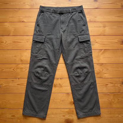 Grey relaxed cargo trousers laid flat on pine wood