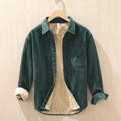 Forest green fleece lined corduroy shirt with a chest pocket hanging on a wooden hanger