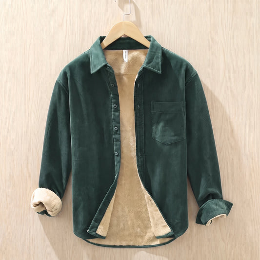 Forest green fleece lined corduroy shirt with a chest pocket hanging on a wooden hanger