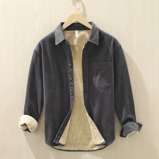 Grey fleece lined corduroy shirt with a chest pocket hanging on a wooden hanger