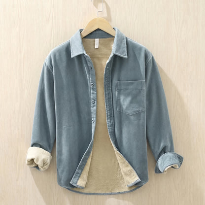 Light blue fleece lined corduroy shirt with a chest pocket hanging on a wooden hanger