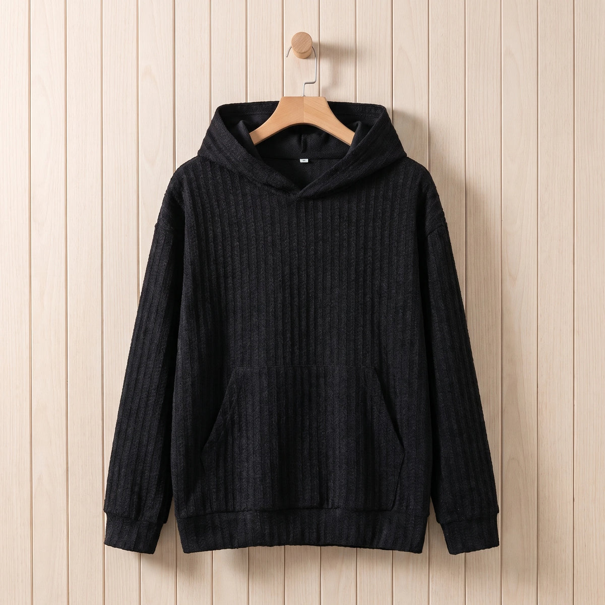Men's black ribbed knit hooded sweater hanging on a wooden hanger