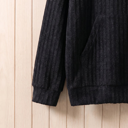 Close-up of the ribbed cuff and hem on the black knit hooded sweater