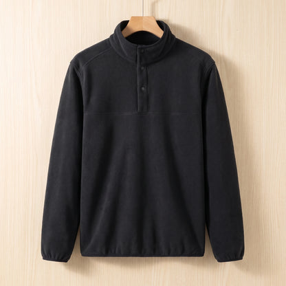 Black fleece pullover with a snap collar and elastic cuffs hanging on a wooden hanger