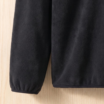 Close-up of the elastic cuff and hem on a soft black fleece pullover