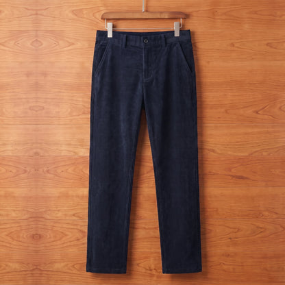Blue straight corduroy trousers hanging on a cherry wood wall