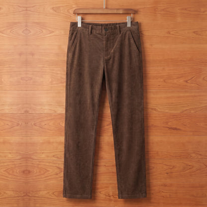 Brown straight corduroy trousers hanging on a cherry wood wall