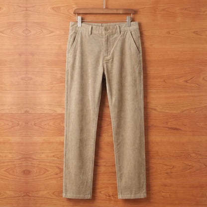 Khaki straight corduroy trousers hanging on a cherry wood wall