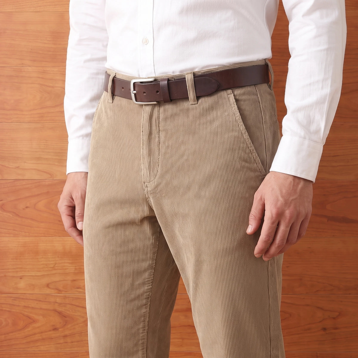 Man wearing khaki corduroy trousers with a white shirt and brown belt