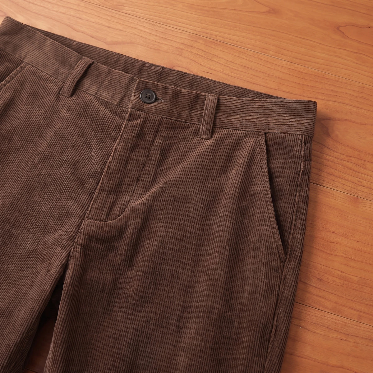 Close-up of the waistband, belt loops and pocket on brown corduroy trousers